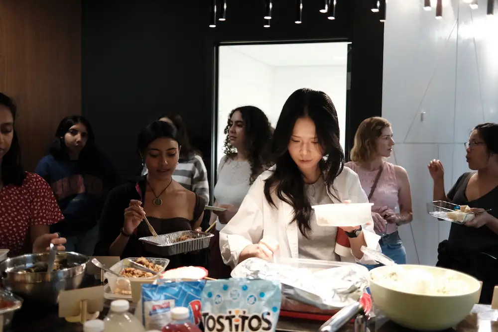 Guests filling their plates from the foil trays along the counter at Sauté Sundays