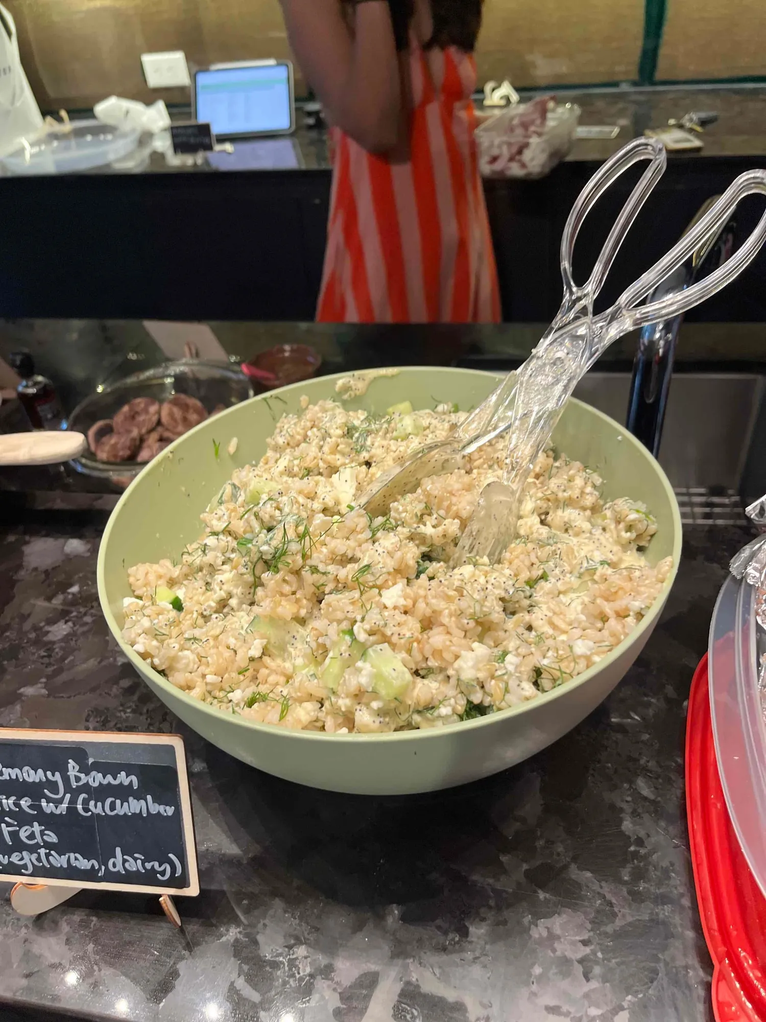 A bowl of rosemary brown rice with cucumber and feta, scattered with dill