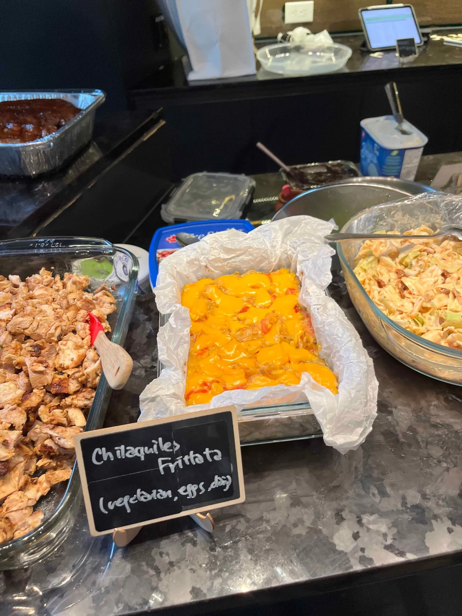 A chilaquiles frittata on the counter, a dish of chopped grilled chicken beside it
