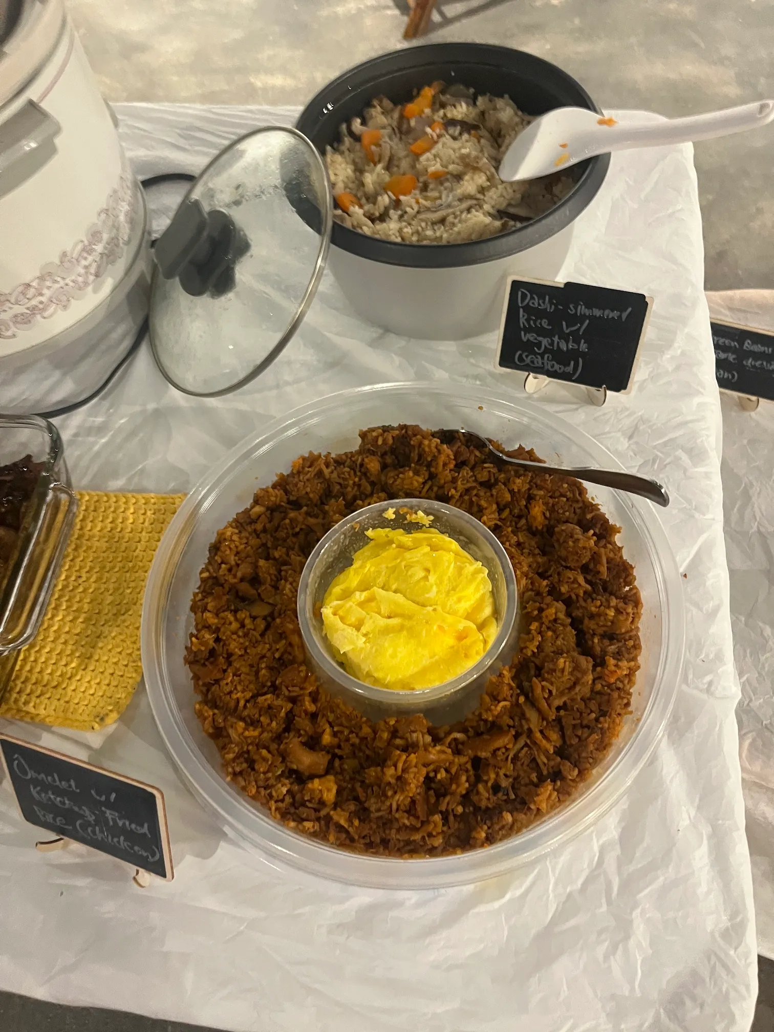 Dashi simmered rice with vegetables next to an omelette with ketchup fried rice, both labelled on small chalkboards